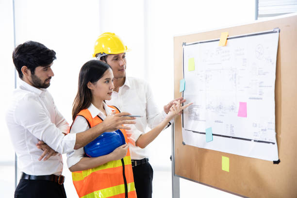 istock Three architects in the office and discussing design project on board. 1255521312