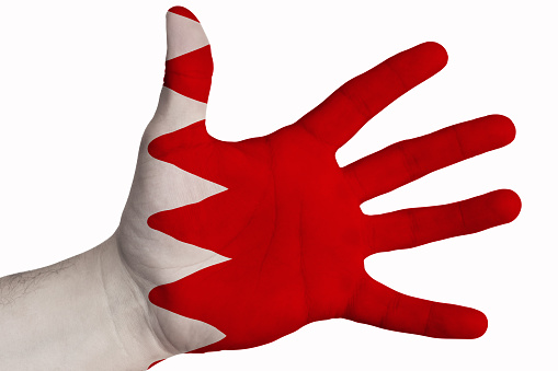 Hand with the image of the flag of Bahrain. Painted as a symbol of perfection, achievement, good. Isolated on a white background