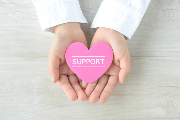 istock Help and support images, heart object covered by child's hands 1255529402