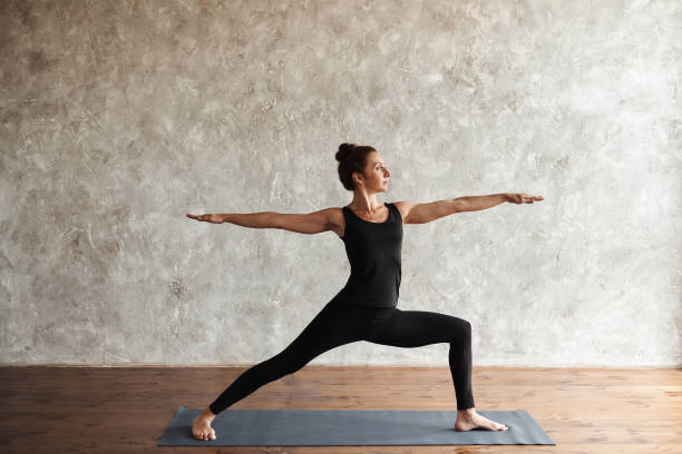istock Woman doing yoga Warrior 2 pose 1255531568