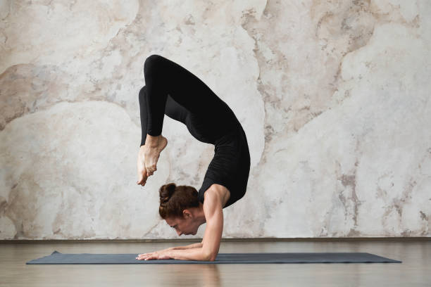istock Woman doing yoga handstand pose 1255532360