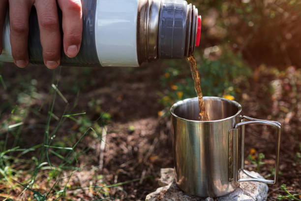 istock In a camping mug pours tea from a thermos in nature. 1255536303