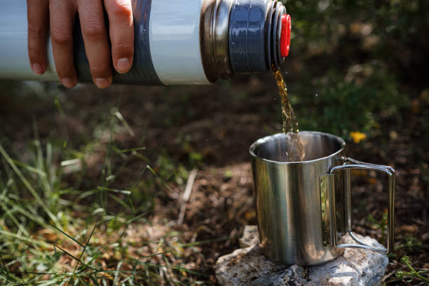istock In a camping mug pours tea from a thermos in nature. 1255536362