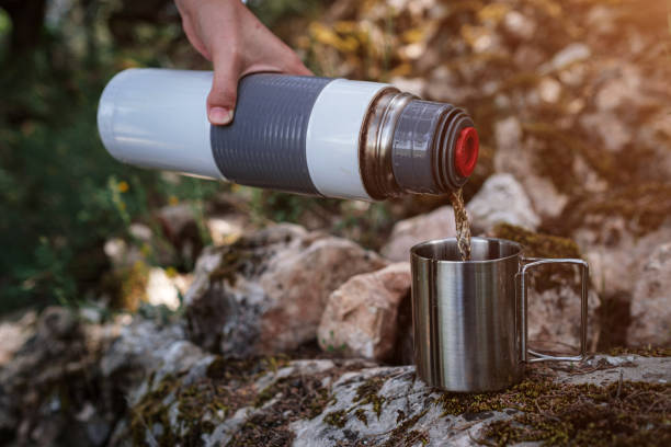 istock In a camping mug pours tea from a thermos in nature. 1255537681