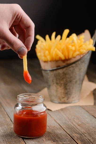 istock Man dips French fries 1255537984