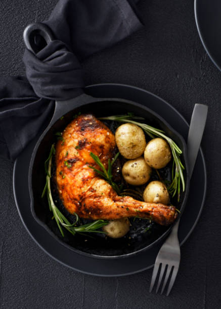 istock Chiken leg and potatoes in a skillet 1255538015