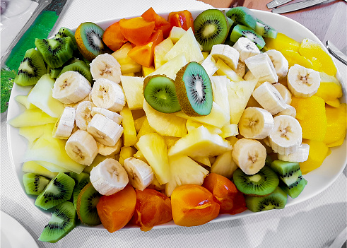 Colorful fruit cut and served on a plate. Breakfast healthy.