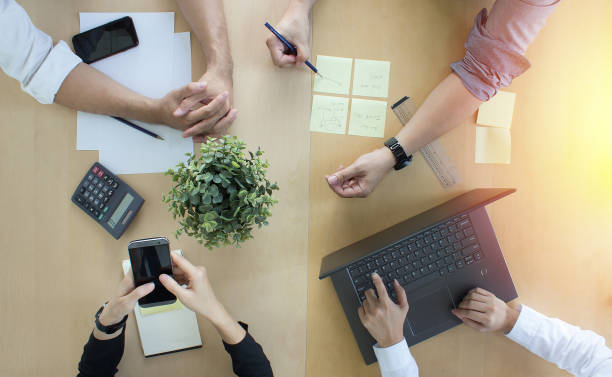 istock Teamwork collaboration with top-down desk view at office.  Brainstorming and setting goals working together. 1255548531
