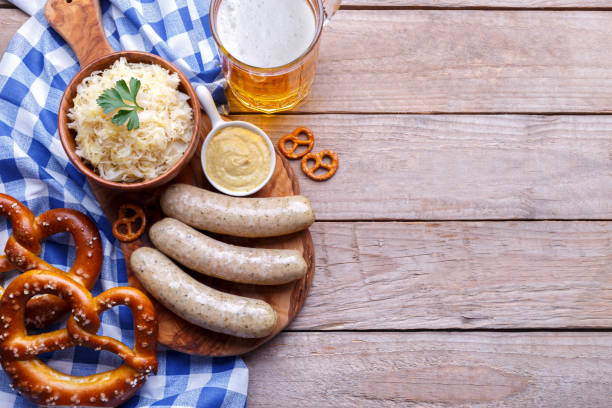 Beer Fest party dinner with traditional dishes Beer Fest party dinner, Bavarian sausages, pretzels, beer, chilly cheese, cabbage salad, mustard sauce, bacon and traditional spaetzle, flat lay top view pub table top view stock pictures, royalty-free photos & images