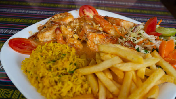 istock Fried breaded shrimp with rice and vegetables on a white plate 1255558998
