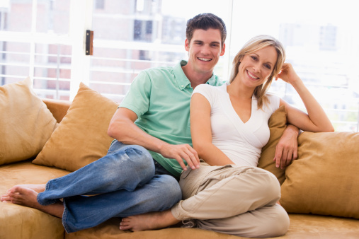 Couple relaxing in living room smiling