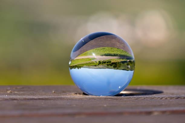 istock Crystal ball with landscape on wooden table 1255561663