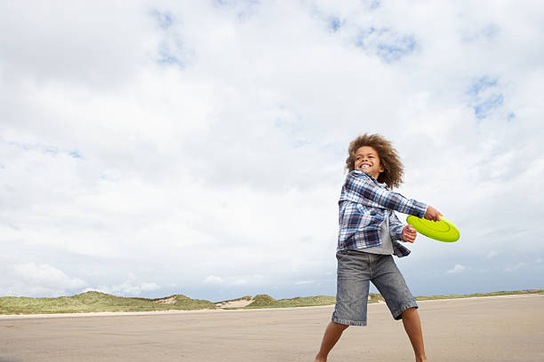 istock Boy playing frisbee on beach 125556282