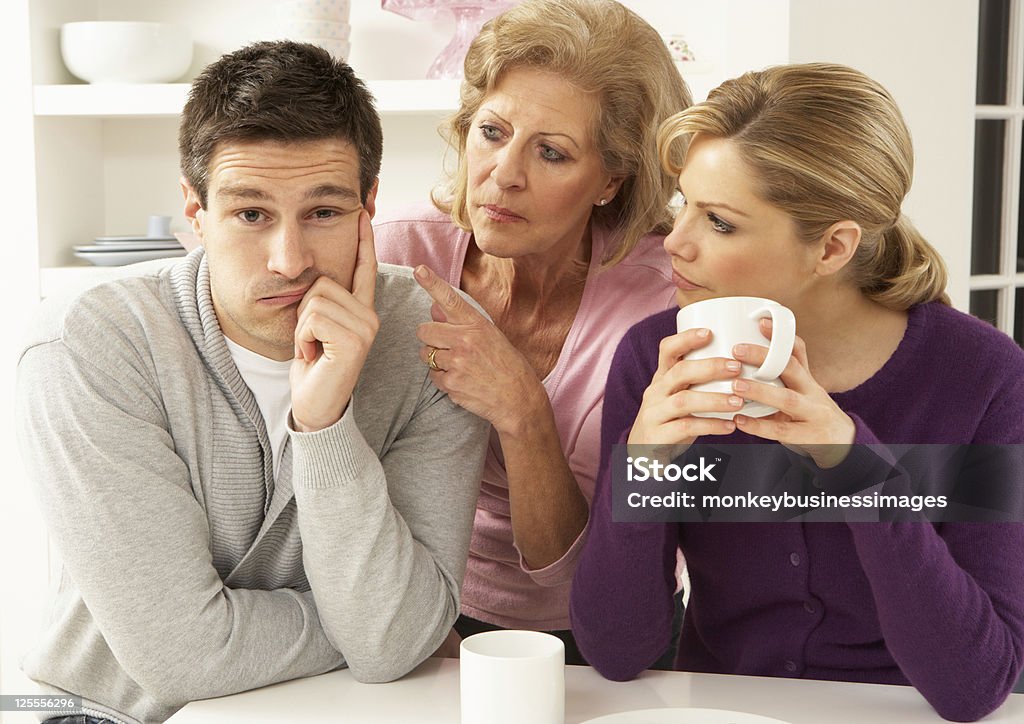 Older woman in between young woman and young man Senior Mother Interferring With Couple Having Argument At Home Mother-In-Law Stock Photo