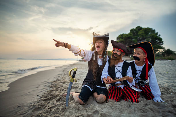 istock Kids pirates looking at treasure map on a beach 1255563655