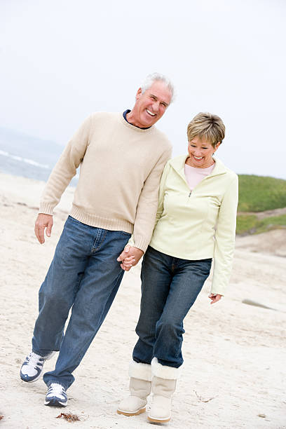 istock Couple at the beach holding hands and smiling 125556429
