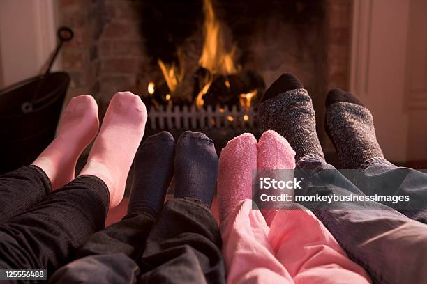 Familia De Pies Calentamiento En Una Chimenea Foto de stock y más banco de imágenes de Invierno - Invierno, Calor, Calcetín