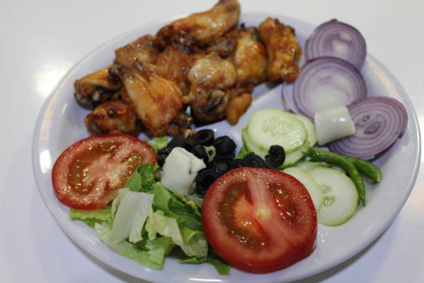 istock Roasted chicken with green salad on food table 1255566762