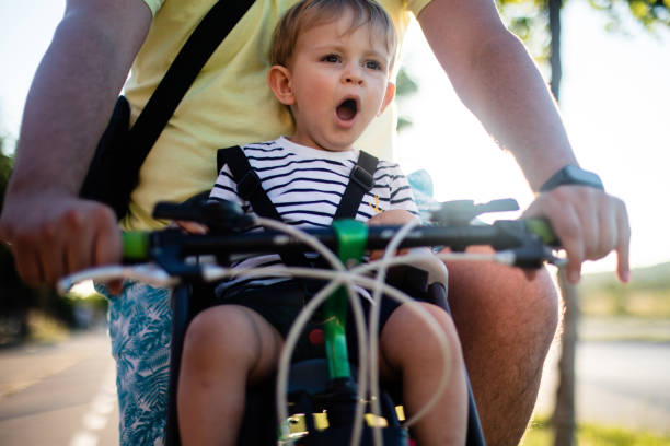 istock Father riding the bicycle with son in the seat 1255567896
