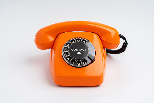 an old orange phone with rotary dial