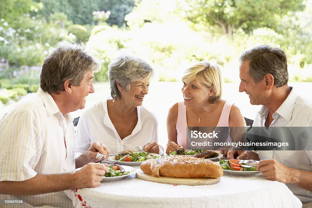 Friends Eating An Al Fresco Lunch Four Senior Friends Eating An Al Fresco Lunch  Meal Stock Photo