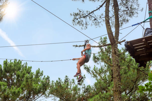 istock pretty young woman doing tree climbing 1255571019