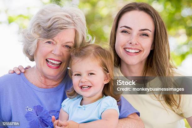 Adulto Nonna Con Figlia E Nipote Nel Parco - Fotografie stock e altre immagini di 70-79 anni - 70-79 anni, Abbracciare una persona, Adulto