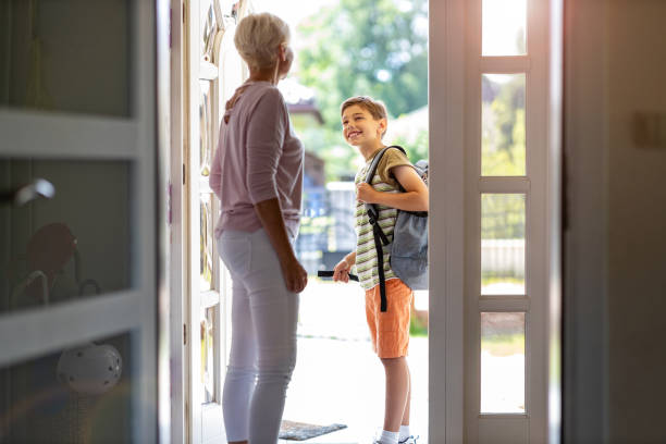 istock Mother and son with backpack in entrance hall 1255572182