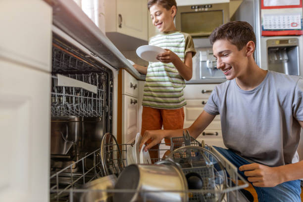 istock Two boys loading the dishwasher together at home 1255572216