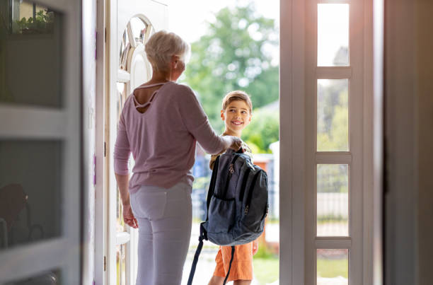istock Mother and son with backpack in entrance hall 1255572324