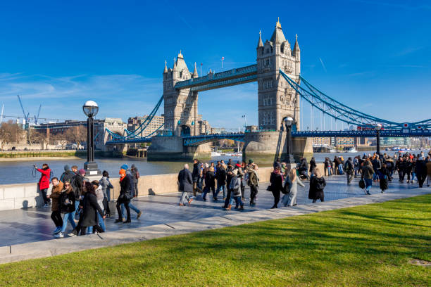 Tower Bridge London London, United Kingdom - Feb 24, 2018: Tourists walk along the Thames, the Tower Bridge in the background. launch tower stock pictures, royalty-free photos & images