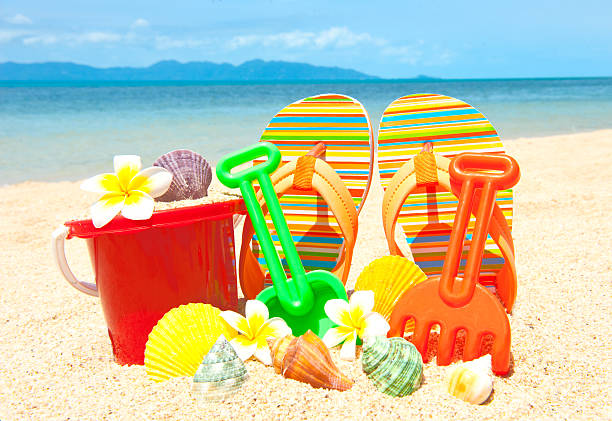 Flowers, seashell, spade and other toys at the tropical beach stock photo