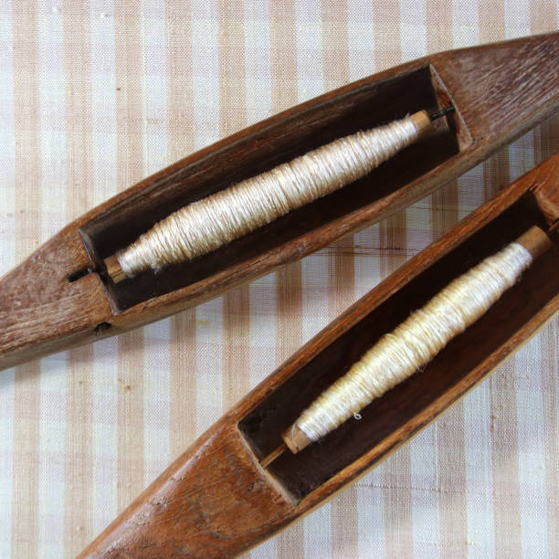 istock wooden bobbin on silk fabric 1255574184