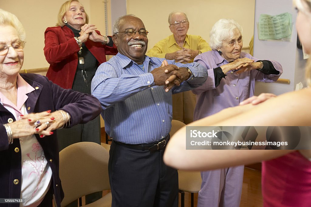 Senior adults in a stretching class Senior adults in a stretching class watching Instructor Senior Adult Stock Photo