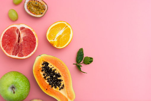 Summer abstract food mock up with fresh fruits frame andcopy space. Pink background.
