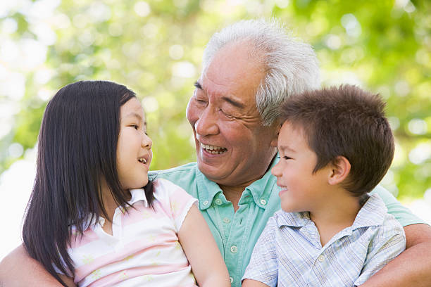 nonno ridere con i nipoti - grandfather adult affectionate little boys foto e immagini stock