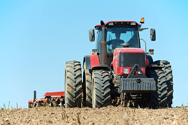 istock A ploughing tractor with farmer at field cultivation to work 125557443