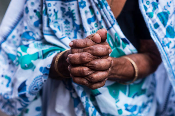 istock An old asian woman with folded hands in white saree 1255574927