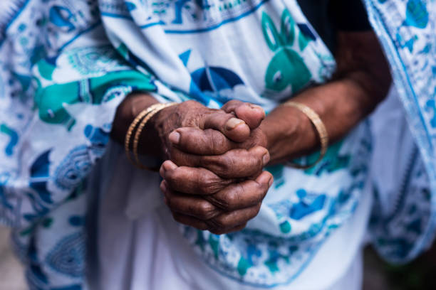 istock An old Asian woman with folded hands in white saree 1255574997