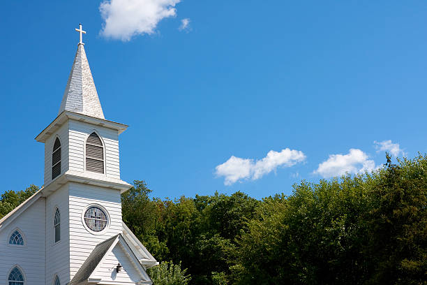 White community church against blue sky Traditional White American community church shot against a blue sky and trees. protestantism photos stock pictures, royalty-free photos & images