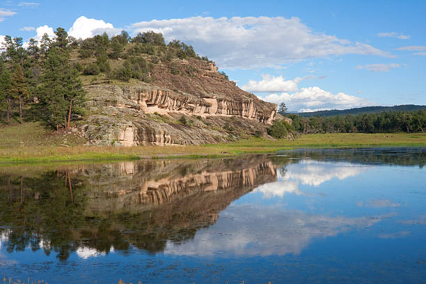 Image of Wall Lake, Gila National Forest, shot in landscape, reflecting the sky and standstone bluff.