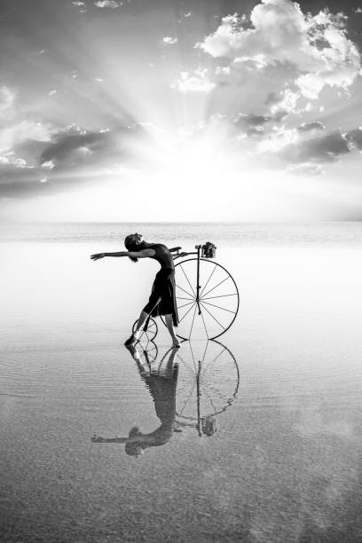 istock Ballerina dancing with old bicycle on the lake 1255576755