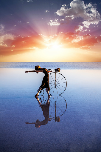 Ballerina dancing with old bicycle on the lake - Salt lake in Turkey