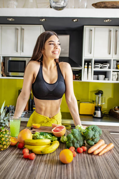 istock Active young woman preparing healthy drink in the kitchen 1255579184