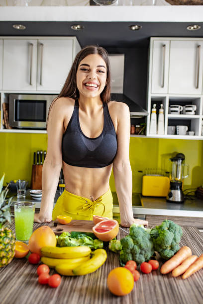 istock Active young woman preparing healthy drink in the kitchen 1255579455