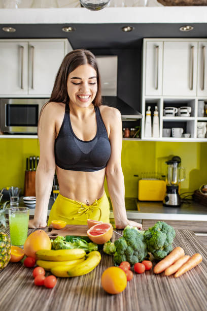 istock Active young woman preparing healthy drink in the kitchen 1255579478
