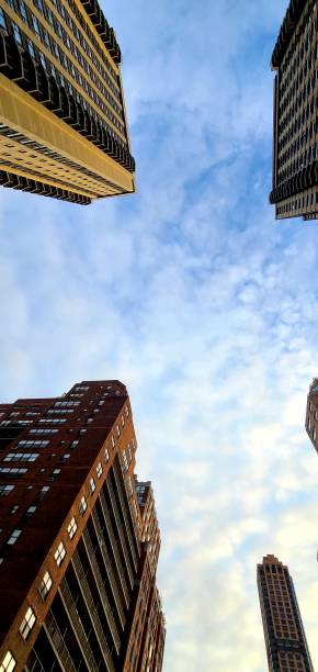 istock Beautiful sky qith clouds under tall buildings view 1255581376