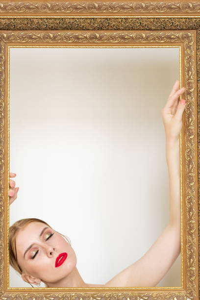 istock Young seductive blond woman with bright makeup keeping her eyes closed 1255582536