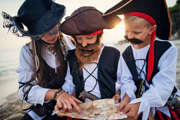istock Kids pirates looking at treasure map on a beach 1255582697