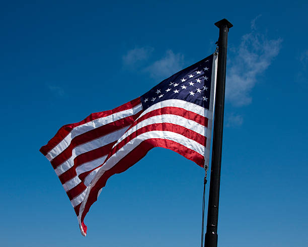 istock The American Flag waving in a blue sky. 125558376
